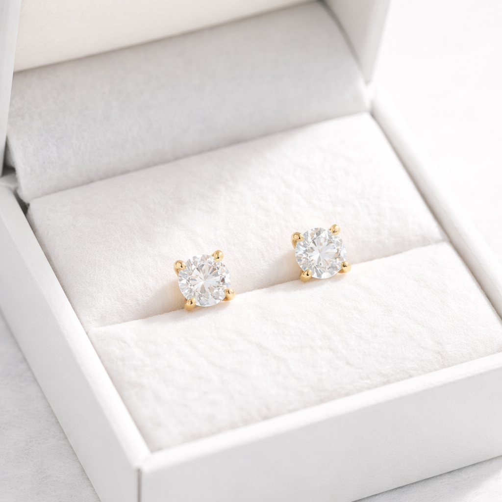 Pair of diamond stud earrings in a white jewelry box