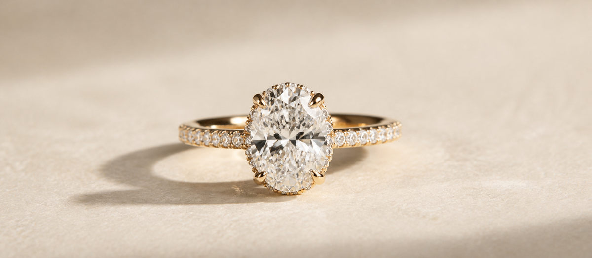 Oval diamond engagement ring on a warm ivory stone surface
