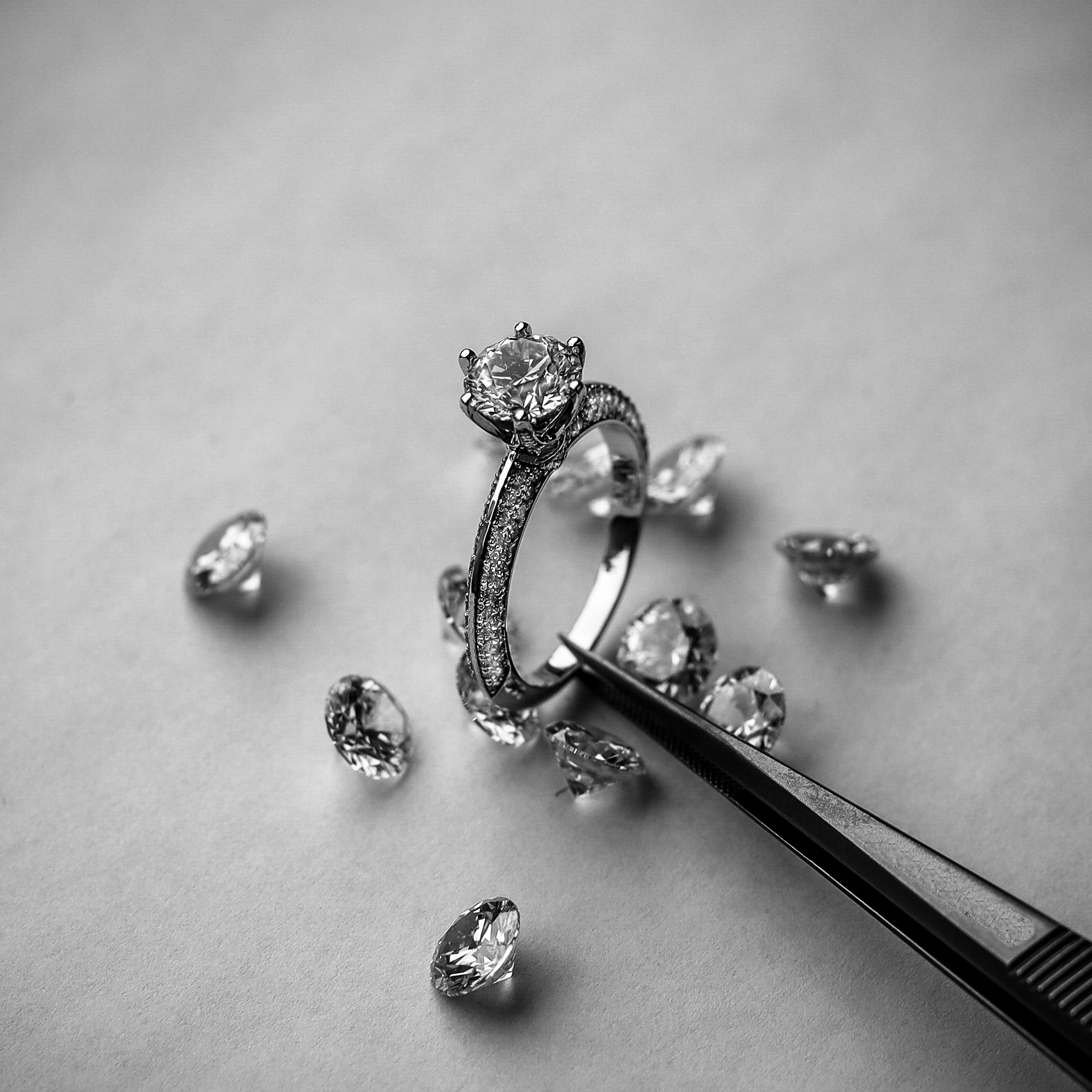 Editorial engagement ring setting styles image with diamonds and tweezers by Atelier RMR