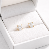 Pair of diamond stud earrings in a white jewelry box