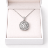 White gold necklace with a round pendant in an open white box on a white background
