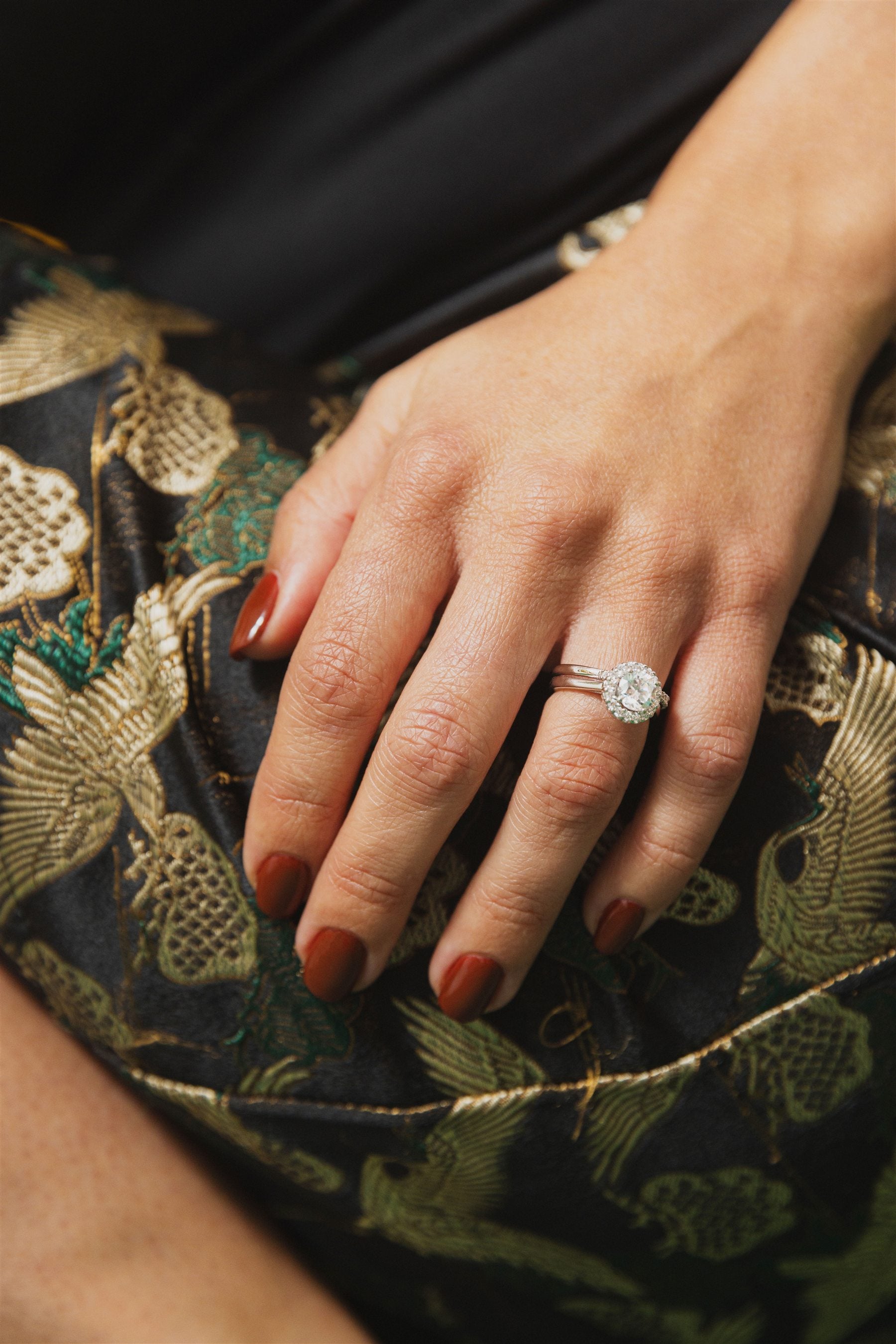 Atelier RMR diamond engagement ring worn against embroidered silk